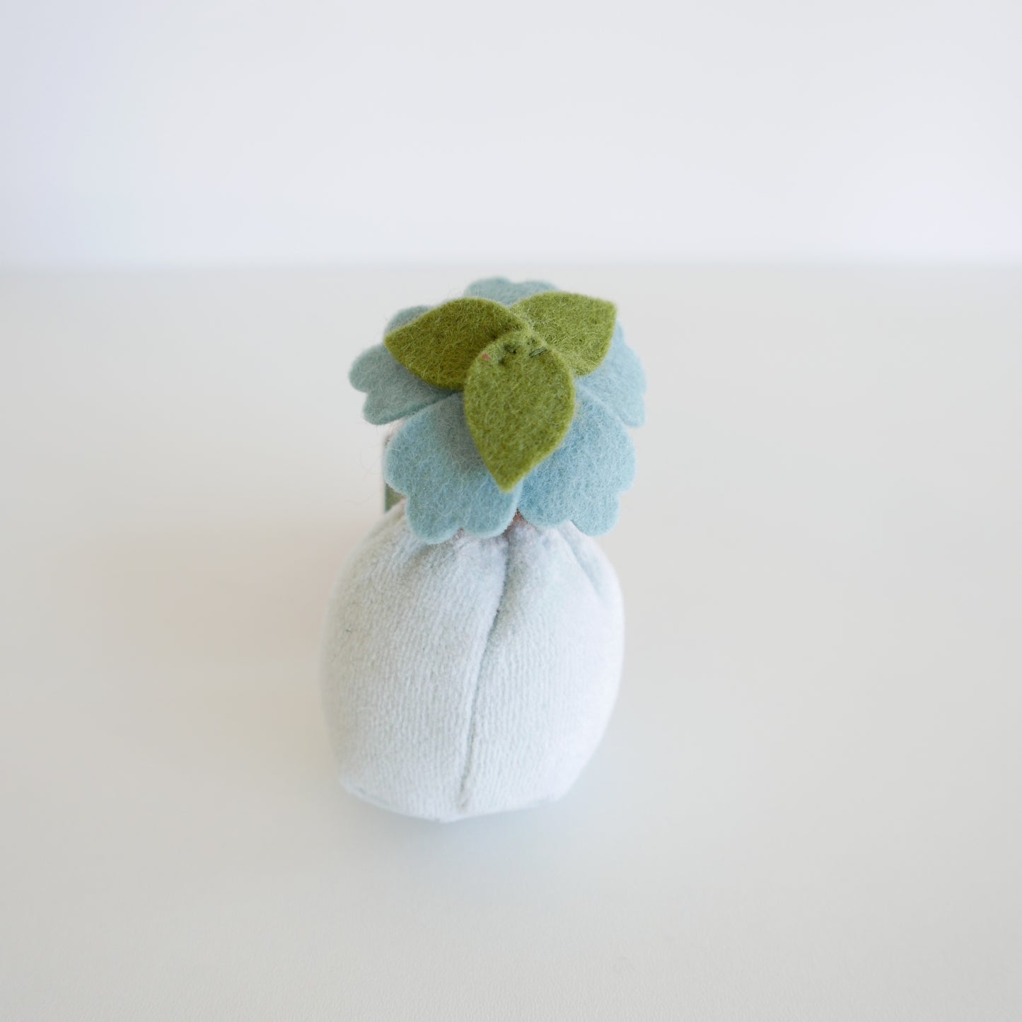 Handmade Blossom Doll named Viola with a delicate purple dress and embroidered floral details, photographed on a white background