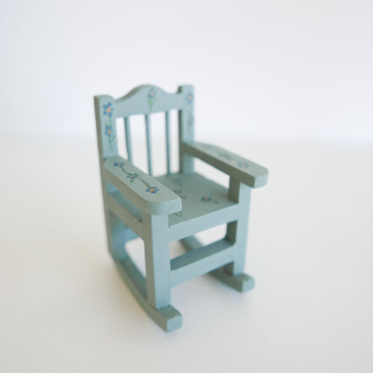 Small green miniature rocking chair on a white background