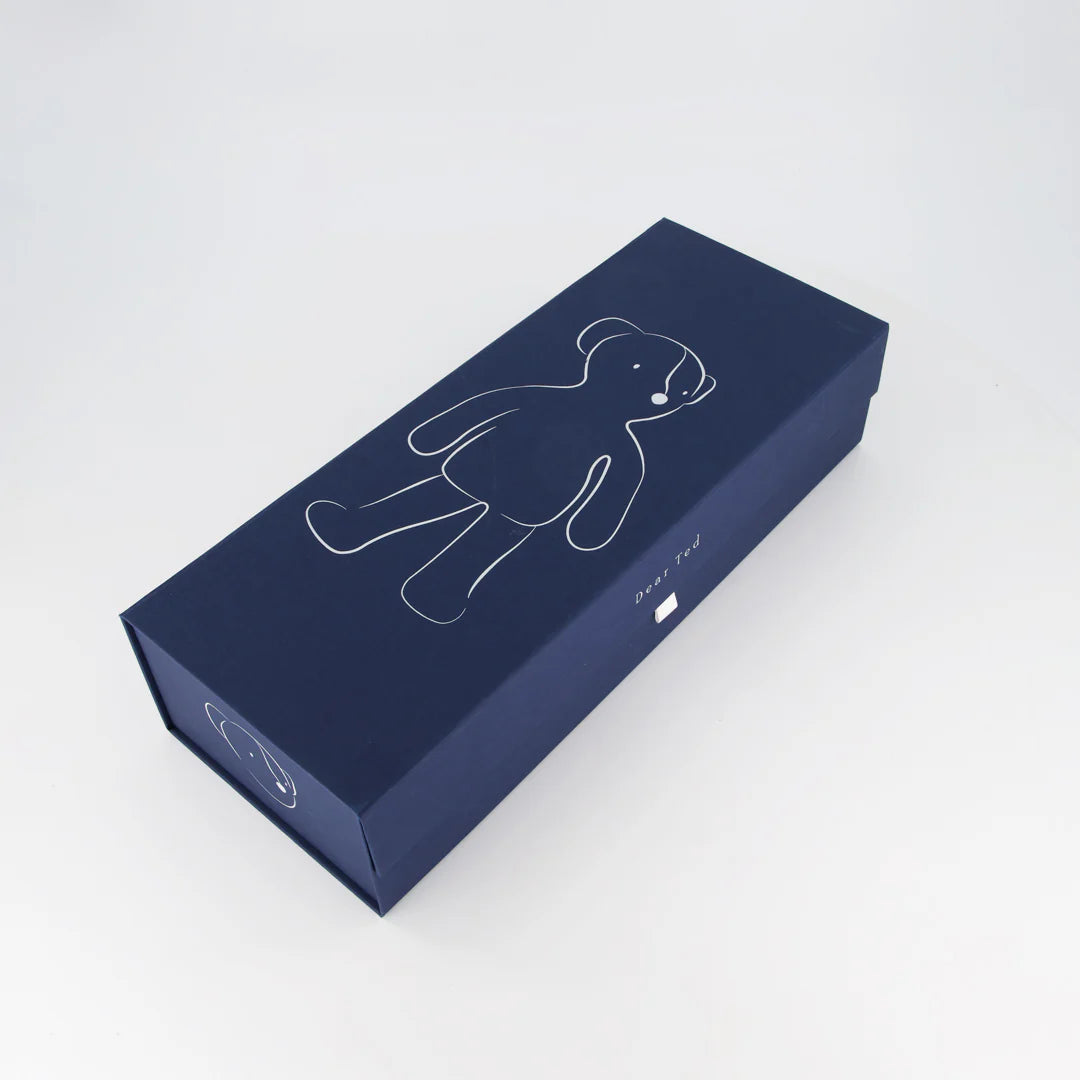 Navy blue box with a white outline of a teddy bear on a light gray background