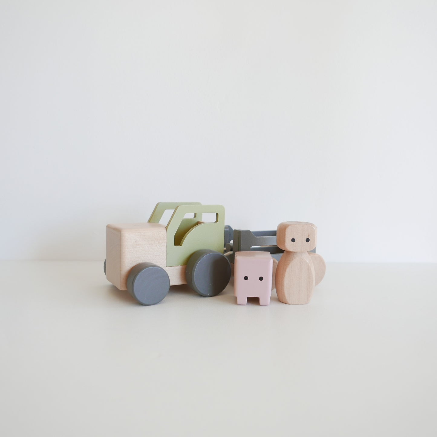 Set of wooden toys including a truck and cars on a light background