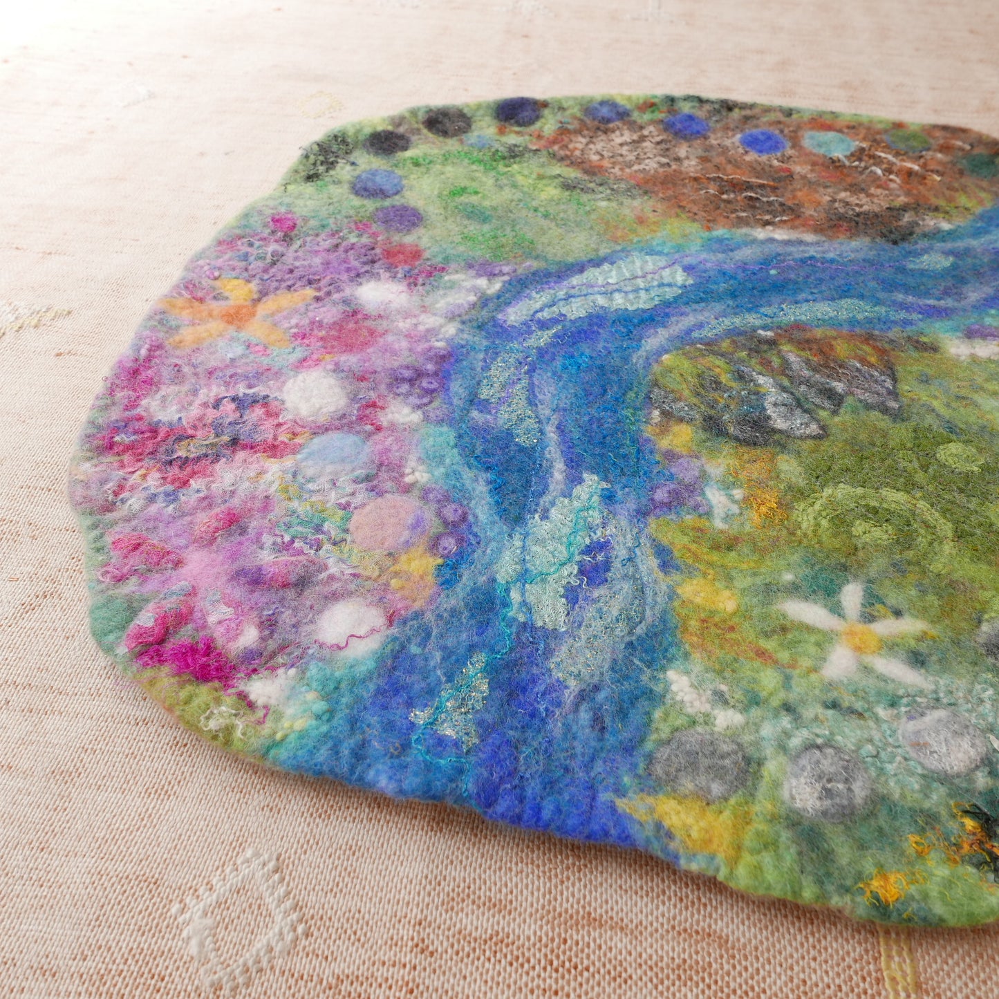 Colorful felted artwork on a textured surface