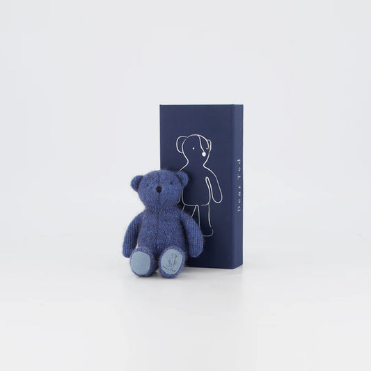Small periwinkle blue teddy bear with stitched facial features, designed for comfort and imaginative play, displayed against white