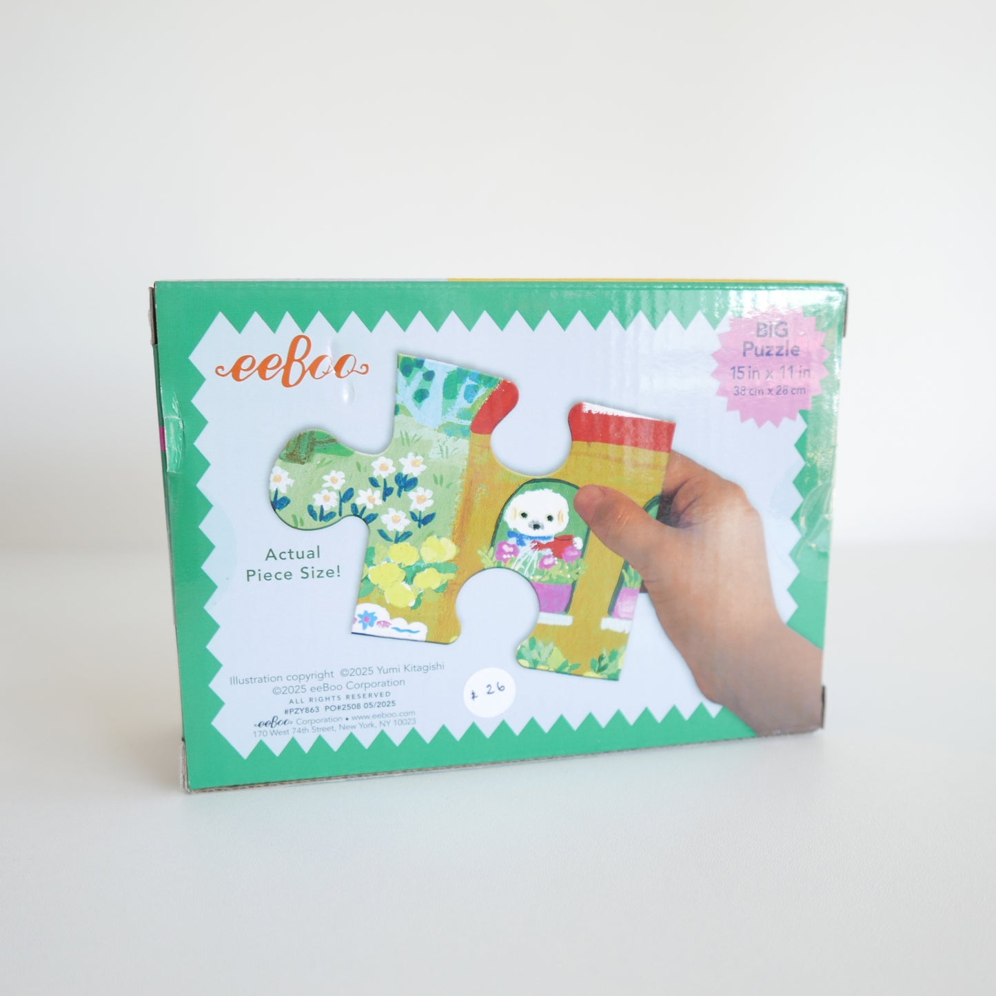 eeBoo puzzle packaging with a hand holding a piece of the puzzle on a white background