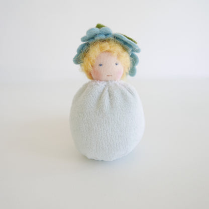 Small plush toy with a floral headband on a white background