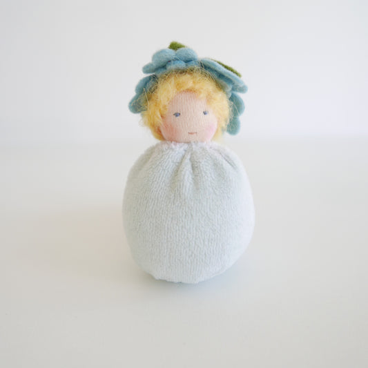 Small plush toy with a floral headband on a white background