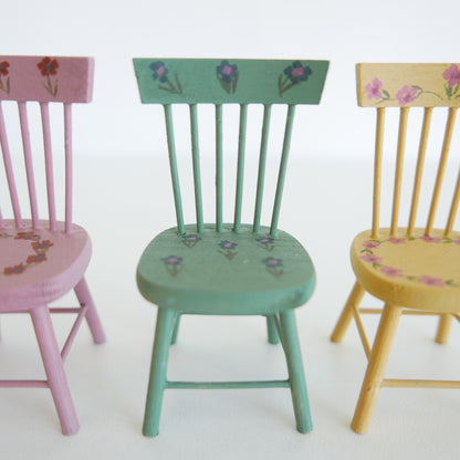 Handcrafted dolls house furniture: small cream-colored dining chair with classic spindle back, shown against white