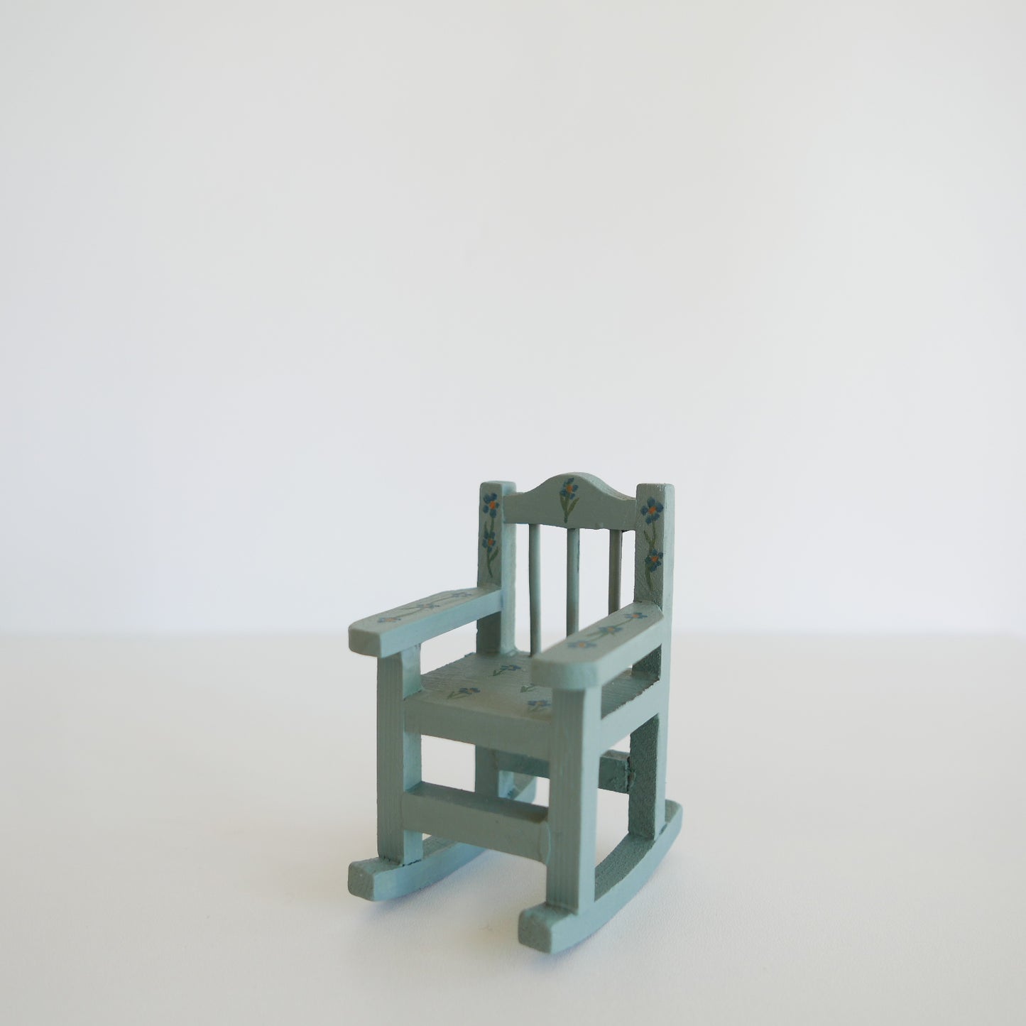 Small green rocking chair on a white background