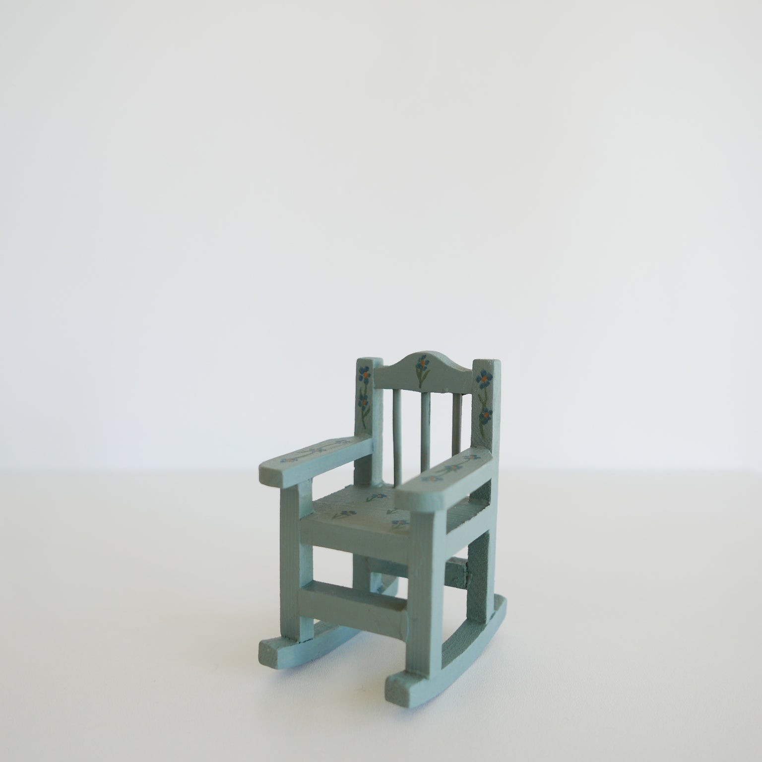 Small green rocking chair on a white background