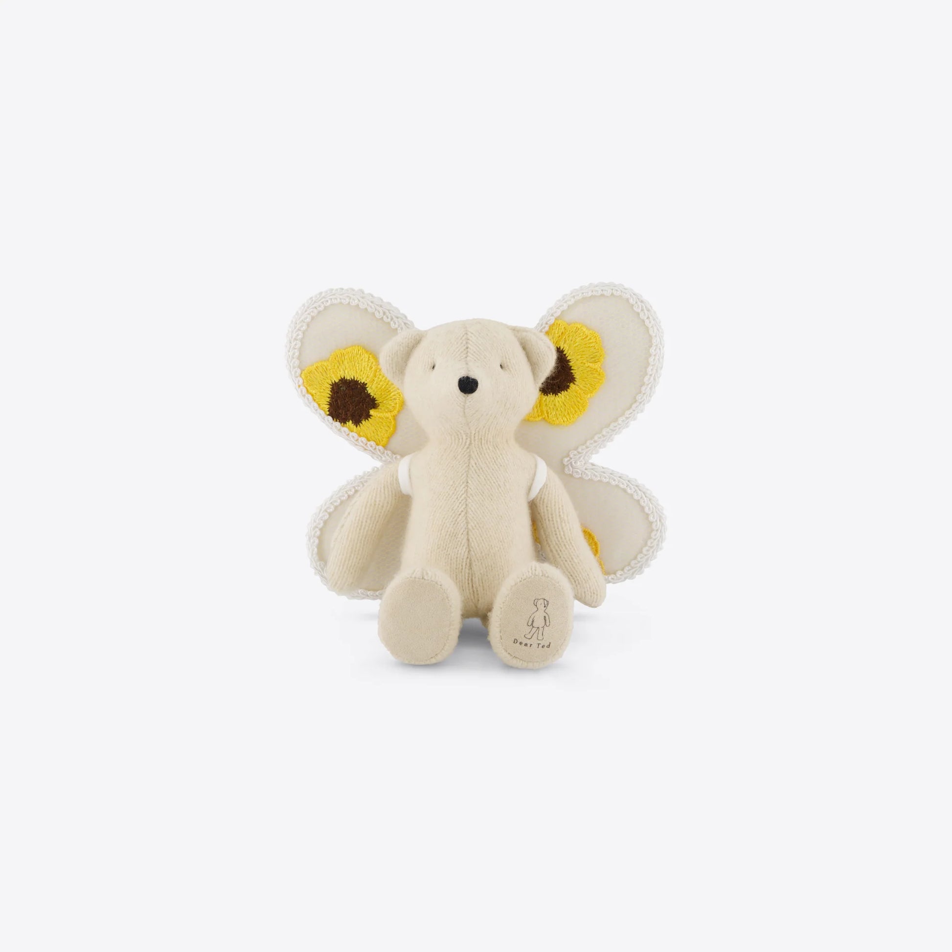 Stuffed toy teddy with yellow butterfly wings on a white background
