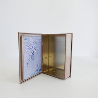 Open book with embroidered fairy design on a white background