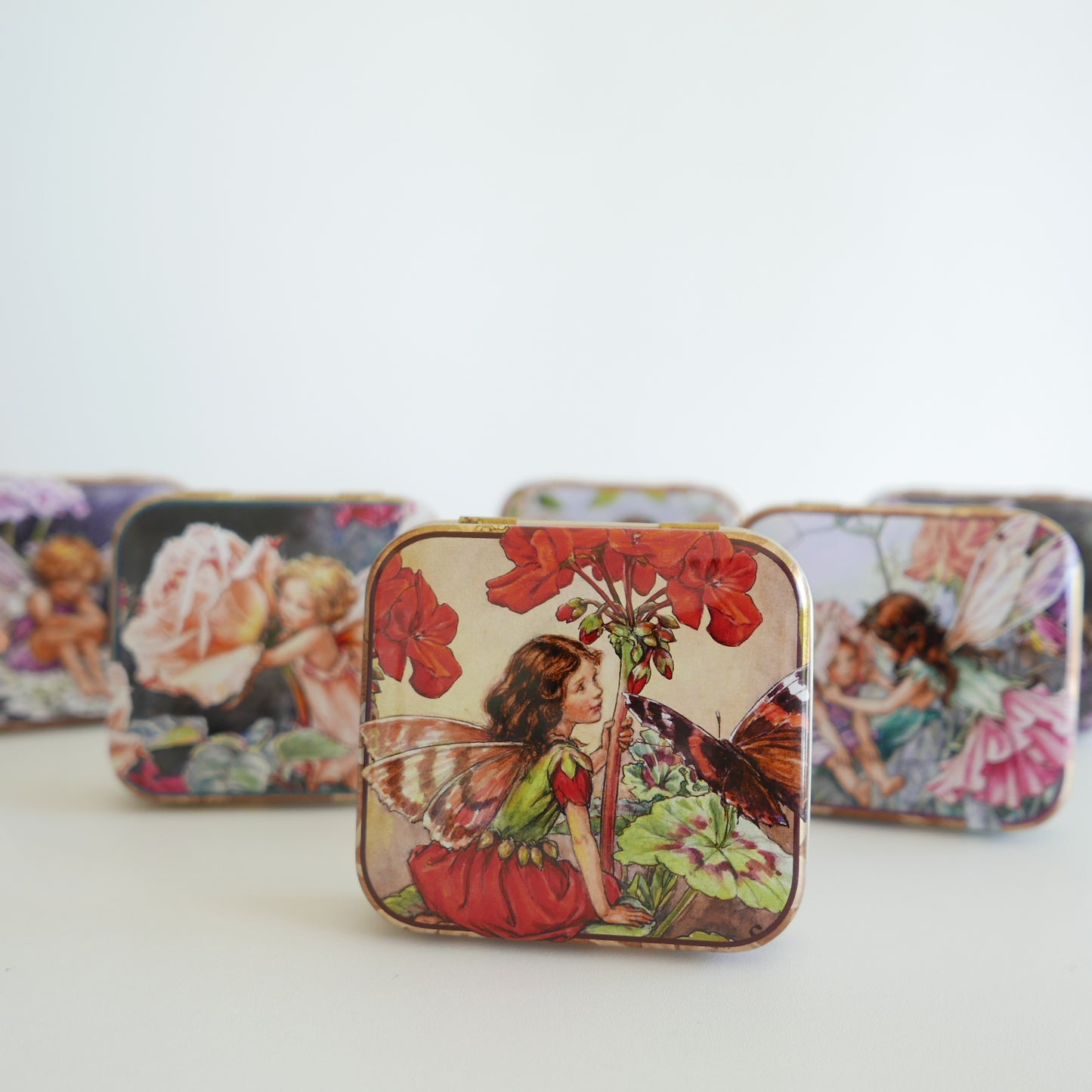Decorative tins with fairy and floral designs 