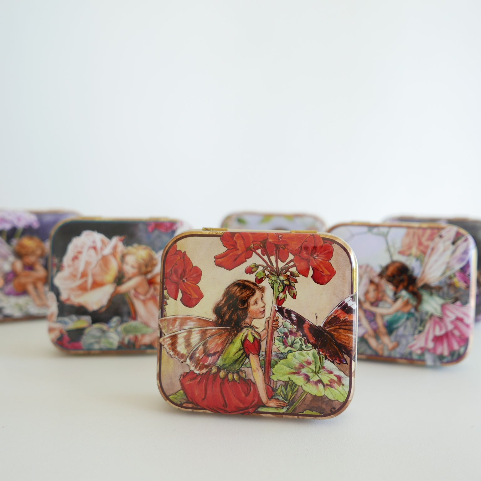 Decorative tins with fairy and floral designs 