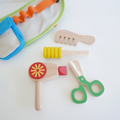 Set of colorful children's play tools including a hammer, scissors, and other items for hairdressing pretend play