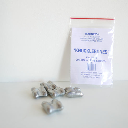 Bag of 'Knucklebones' with warning label on a white background