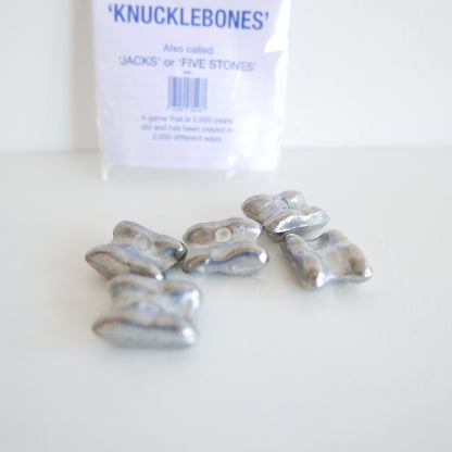 Silver knucklebones with packaging labeled 'Knucklebones' on a white background