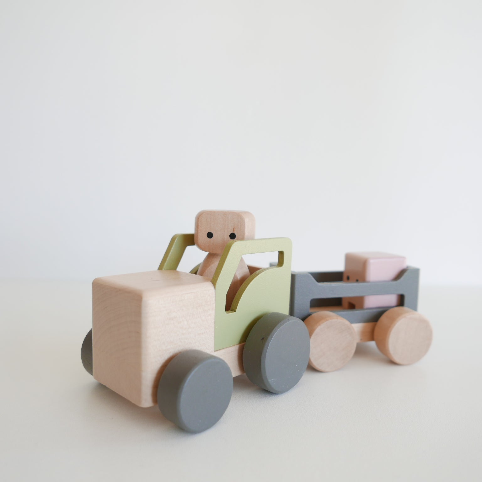 Wooden toy truck with a driver figure on a white background