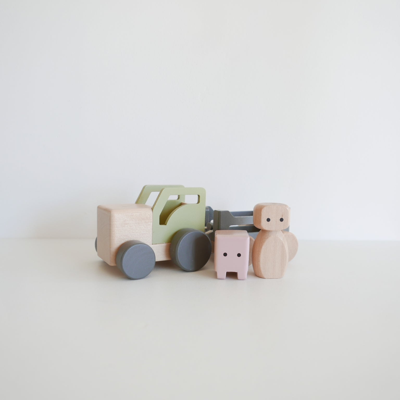 Set of wooden toys including a truck and cars on a light background