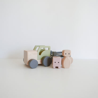 Set of wooden toys including a truck and cars on a light background