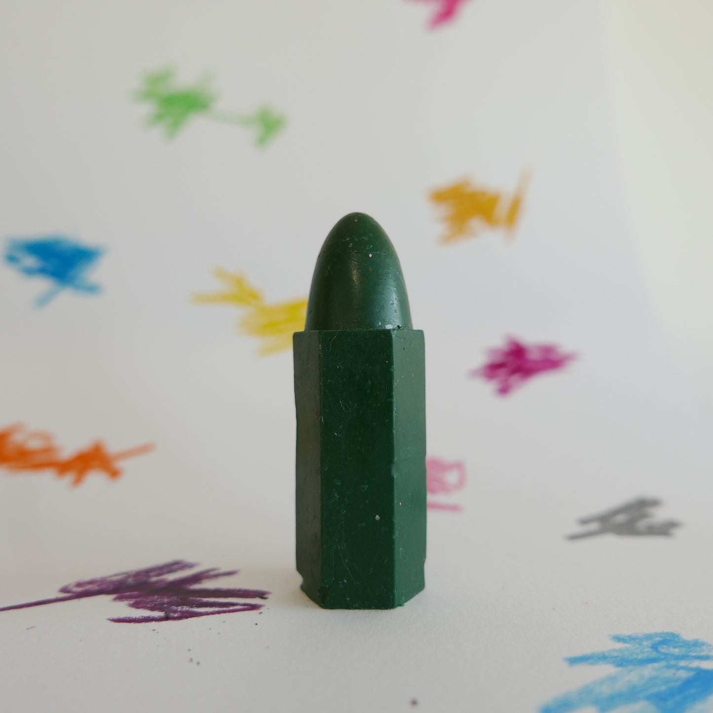 Focus on green Cognito crayon with scribble background

