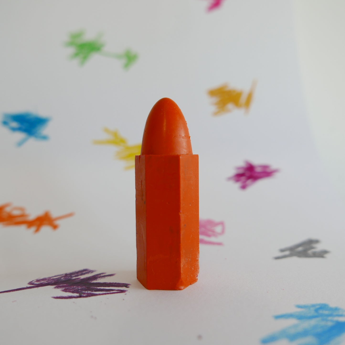 Focus on orange Cognito crayon with scribble background

