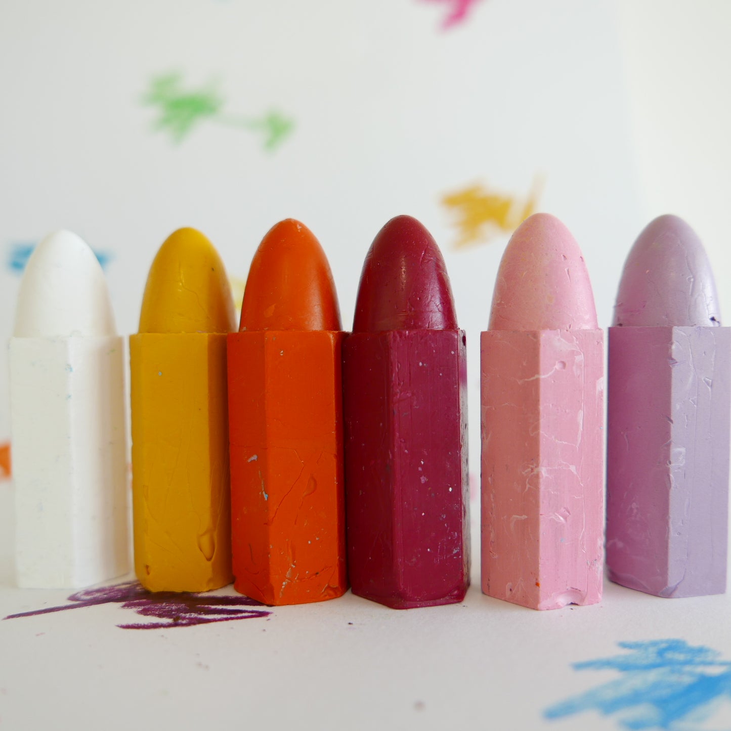 Set of colorful crayons on a white background with artistic smudges.