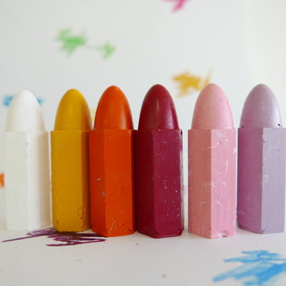 Set of colorful crayons on a white background with artistic smudges.
