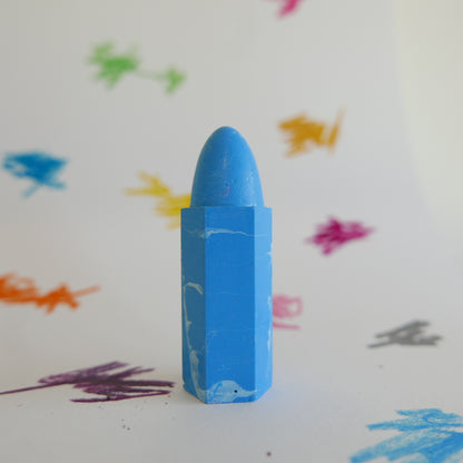 Blue crayon on a white background with colorful crayon strokes