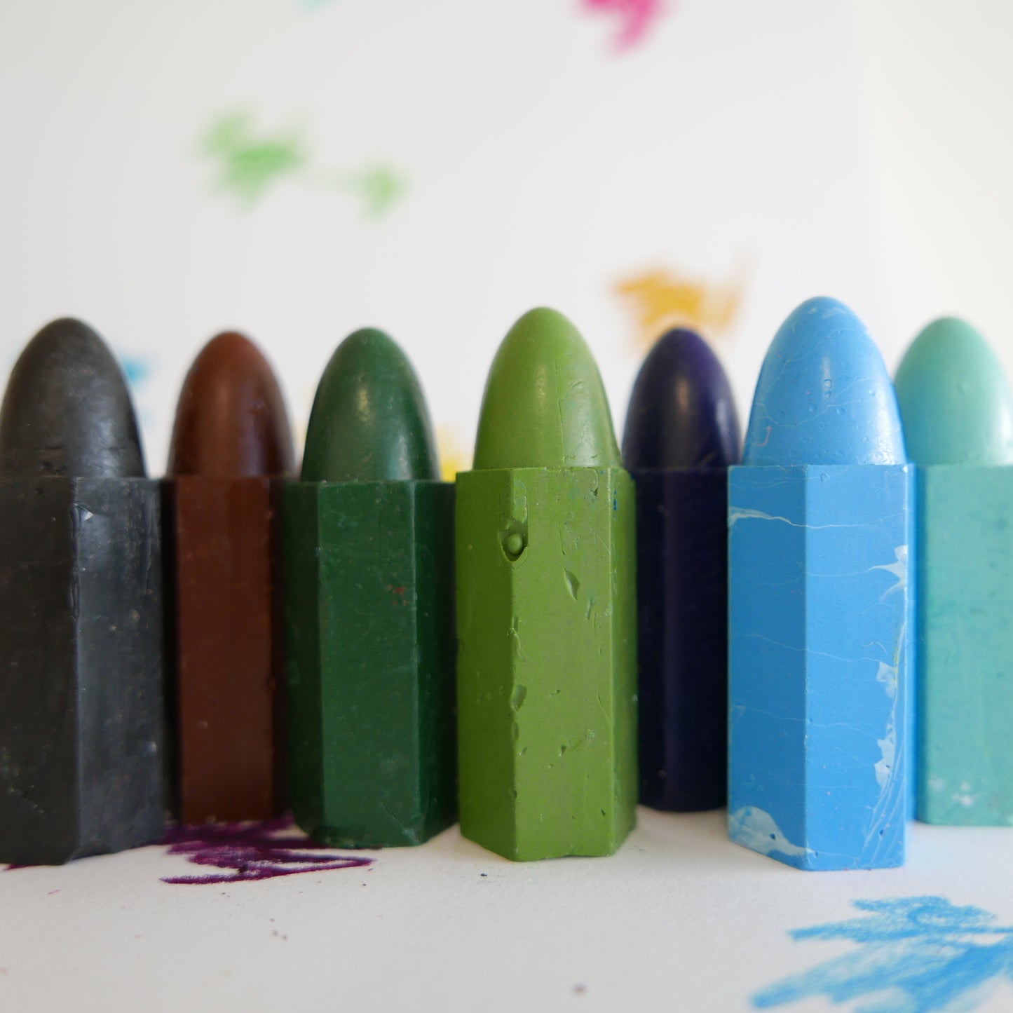 Set of colorful crayons on a white background with artistic smudges.
