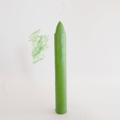 Green crayon stick made locally highlighted on plain background
