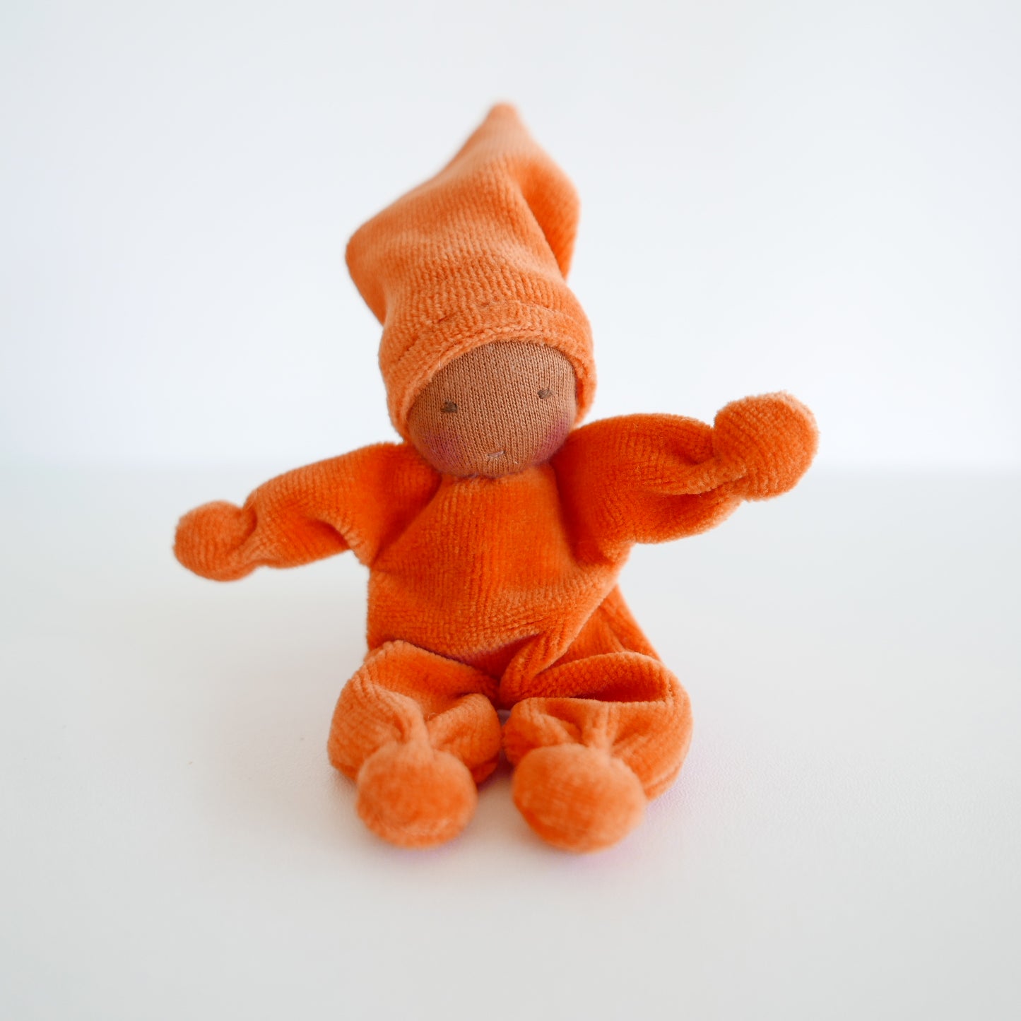 Small orange plush toy on a white background