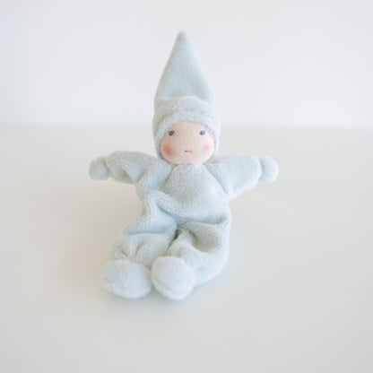 Textile baby doll with a blue outfit on a white background