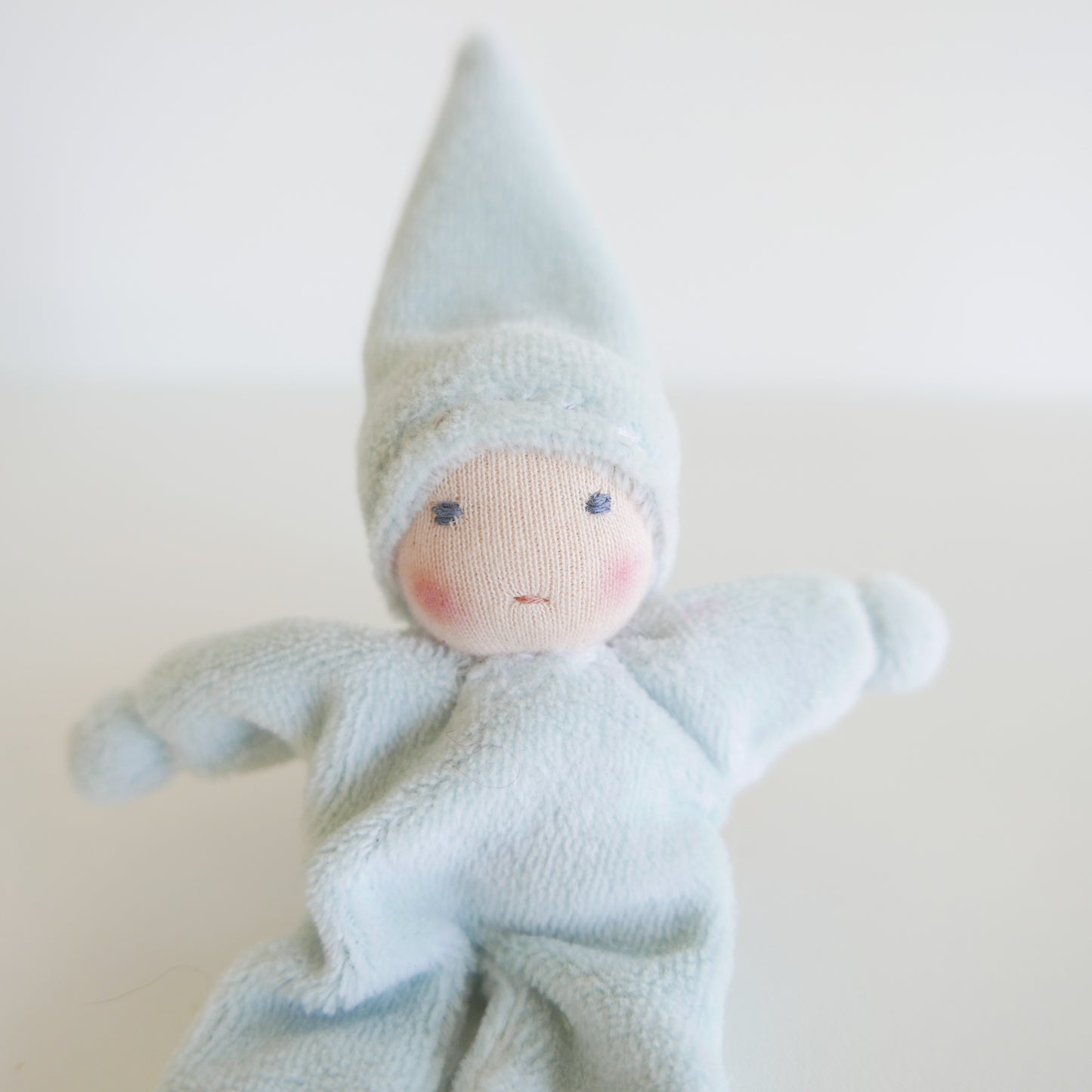 Small angel doll with a soft blue color on a light background