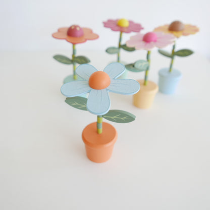 wooden Colorful flower-shaped objects with green stems on a white background