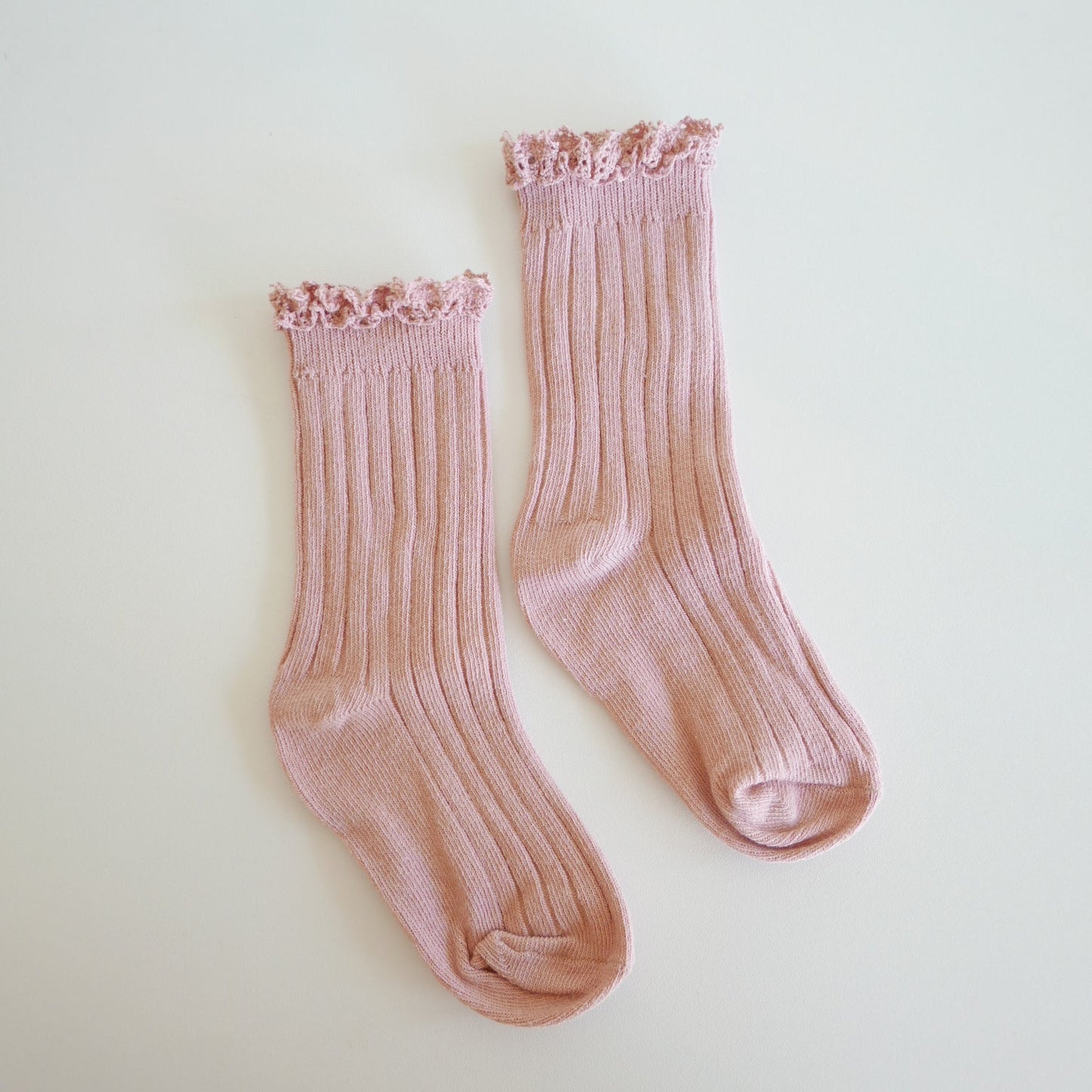 Pair of pink socks on a light beige background