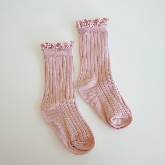 Pair of pink socks on a light beige background