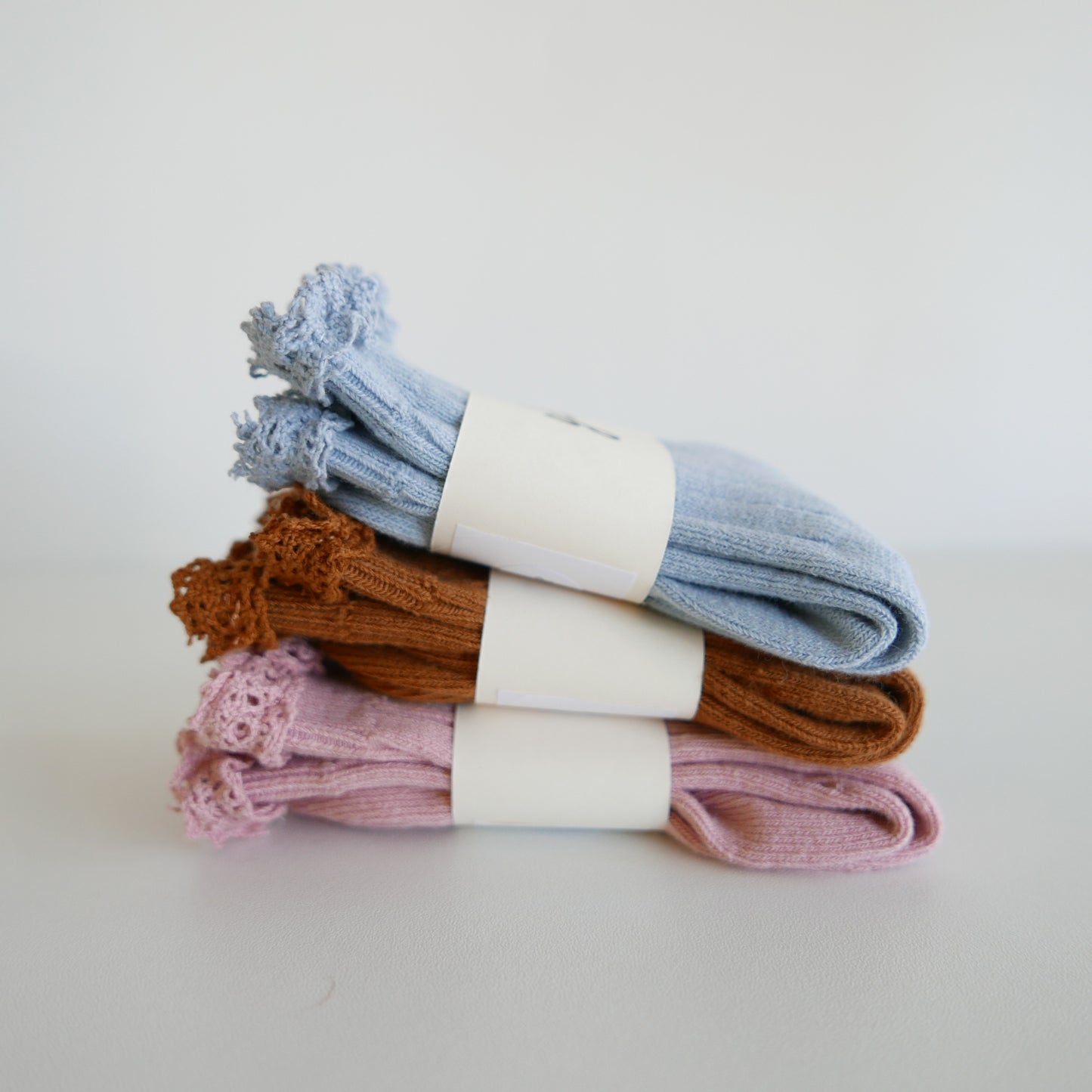 Stack of colorful socks with white labels on a light background