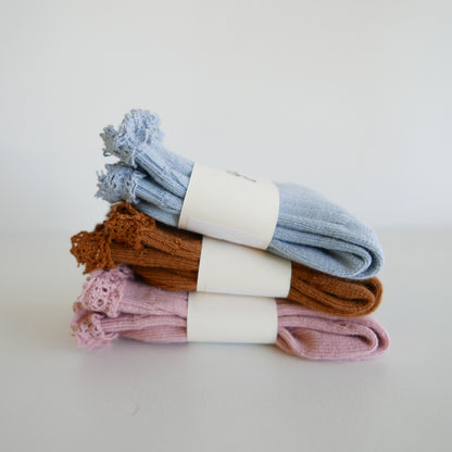 Stack of colorful socks with white labels on a light background