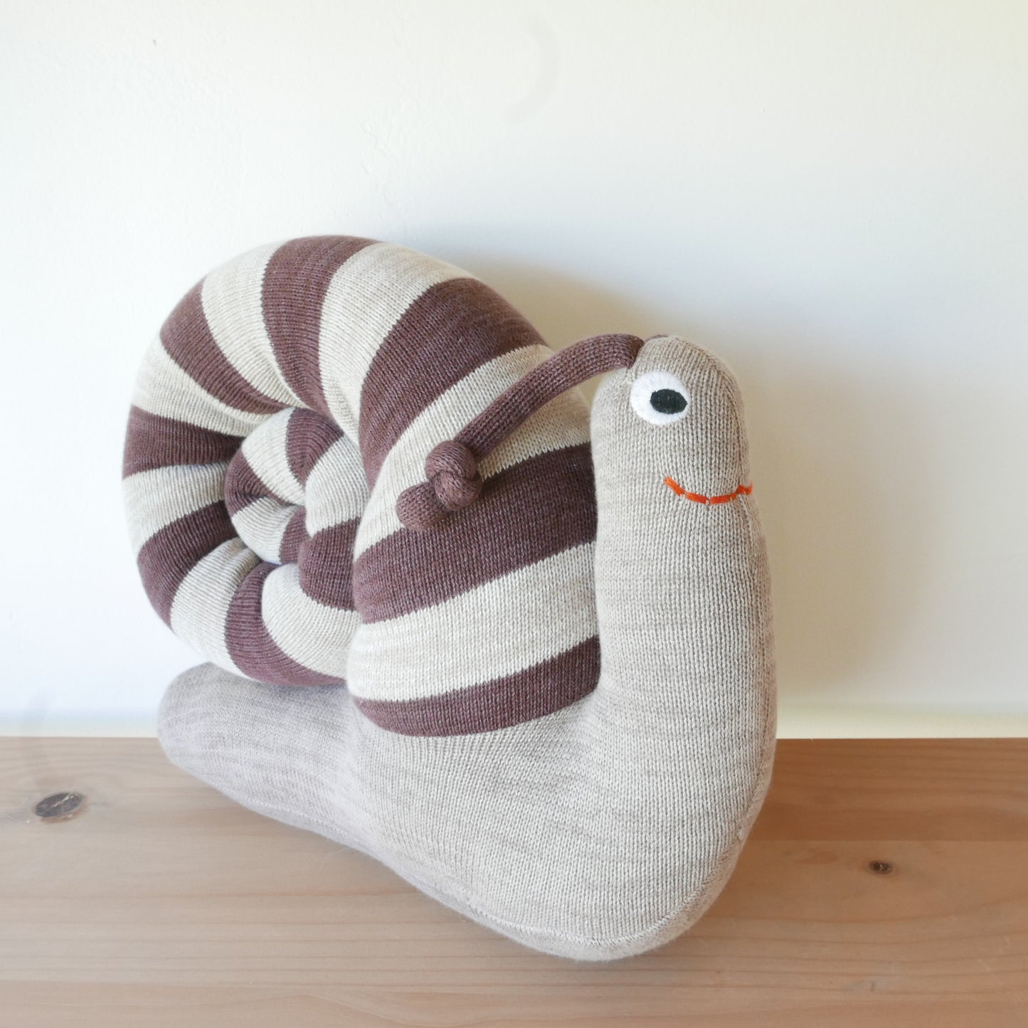 Sally Snail plush displayed on a white background

