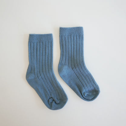 Pair of blue socks on a light gray background