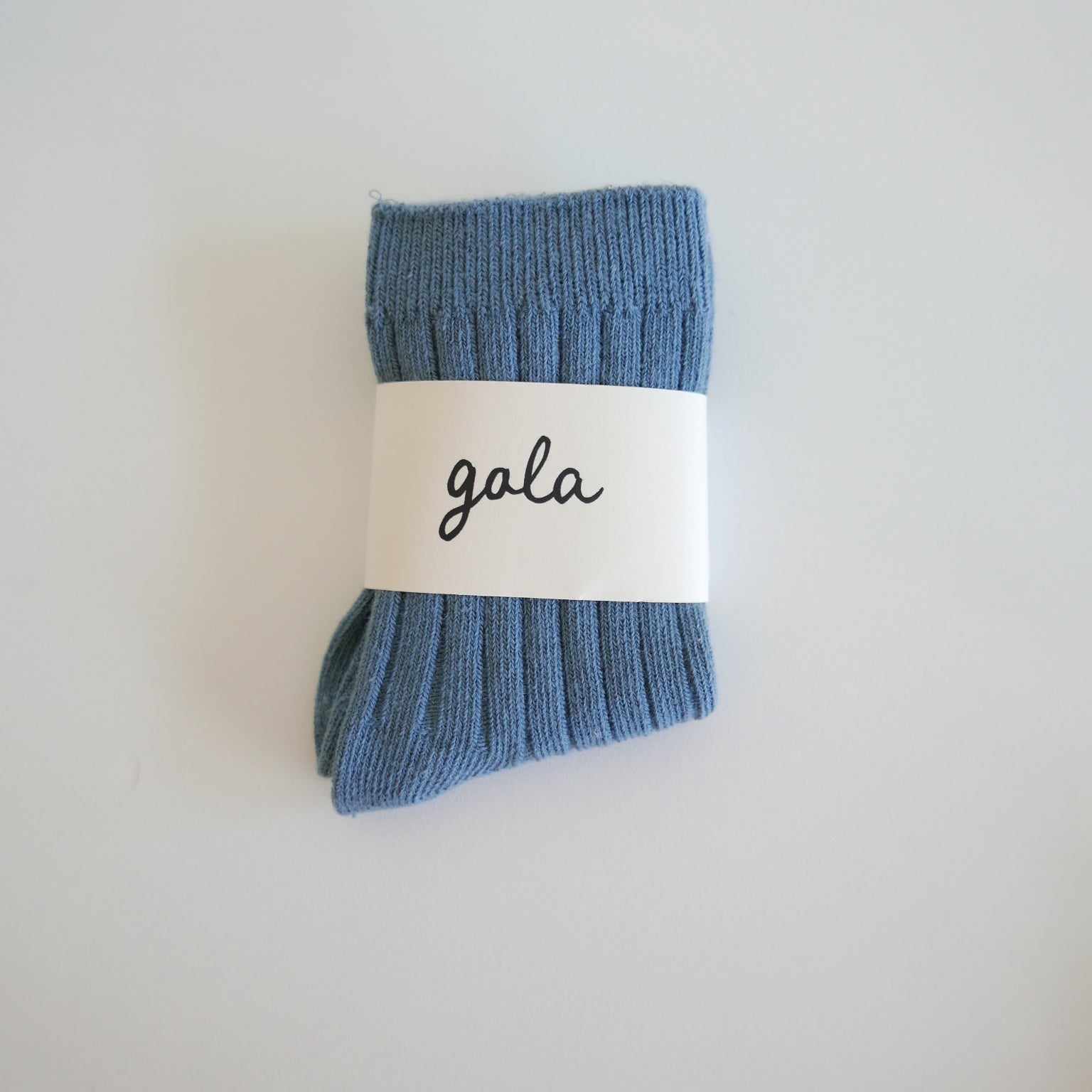 Blue sock with a 'gala' label on a light gray background
