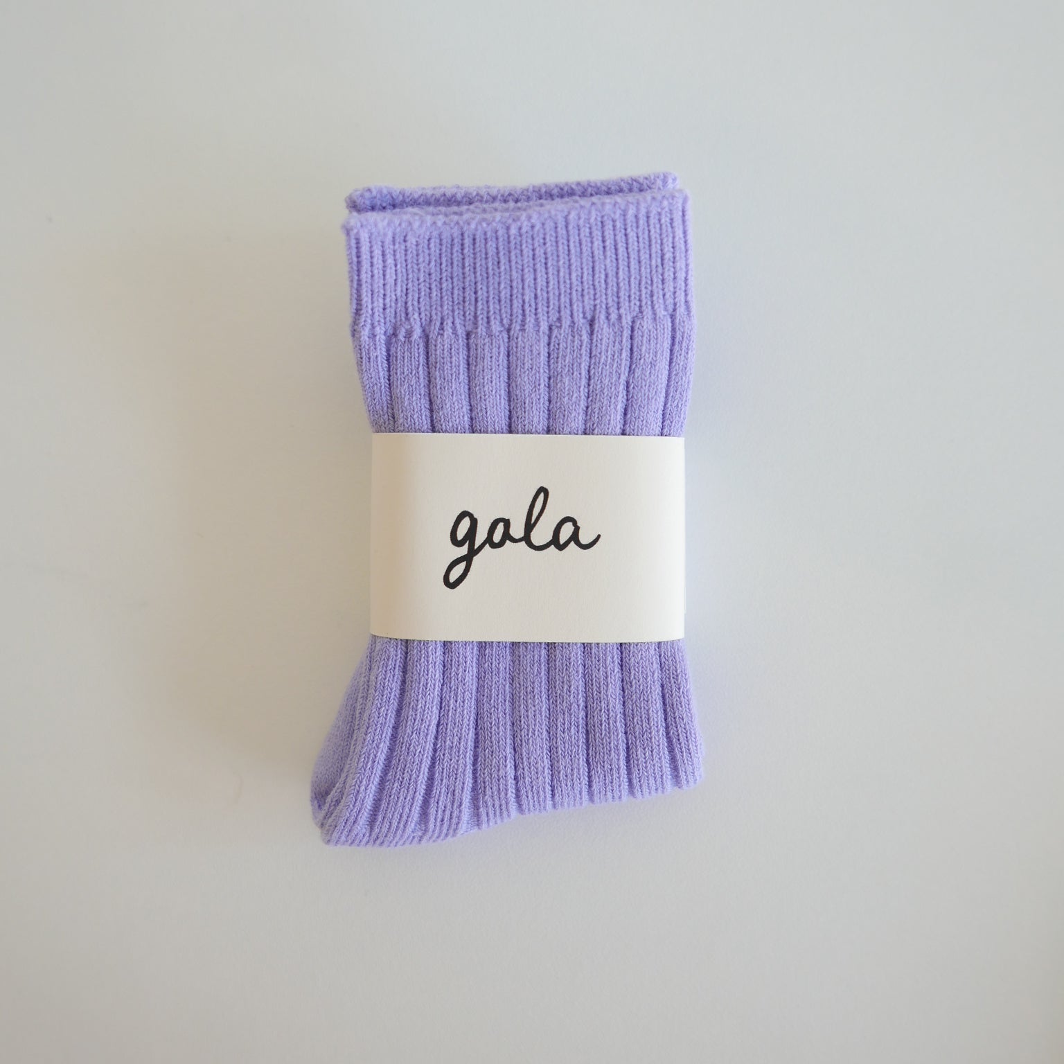Pair of purple socks with a 'gala' label on a light gray background