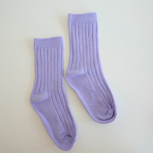 Pair of lavender socks on a light beige background