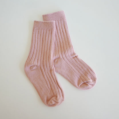 Pair of pink socks on a light beige background