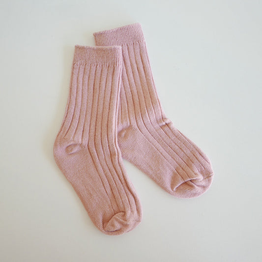 Pair of pink socks on a light beige background
