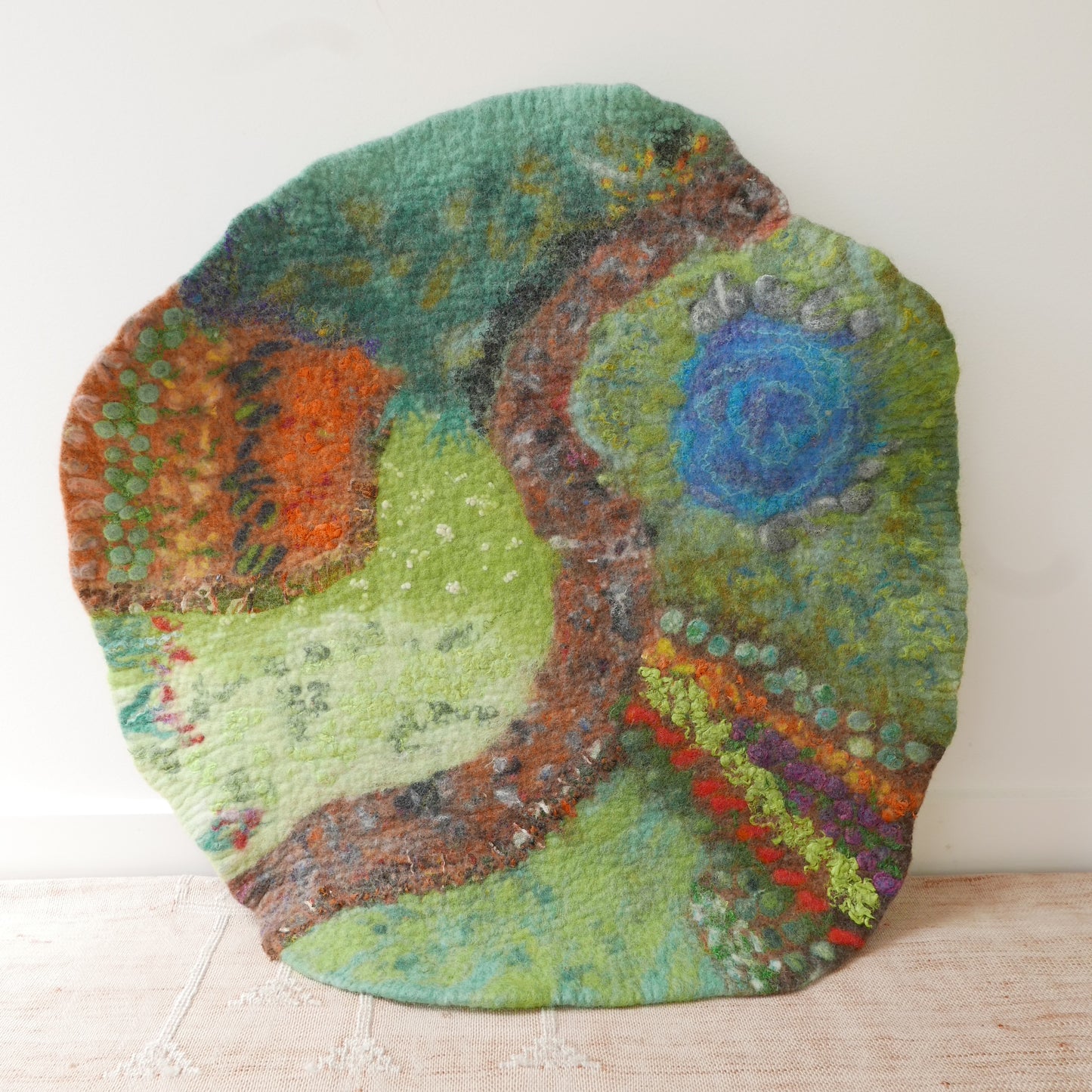 Colorful round rug with a design on a light wooden floor