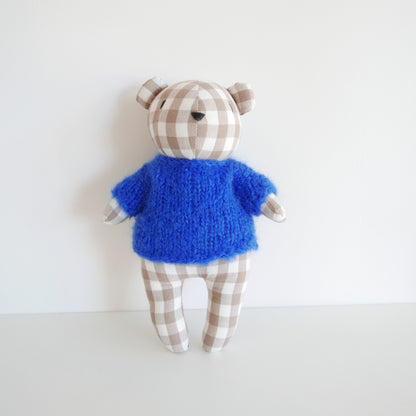 Toy figure with blue torso and checkered arms and legs on a white background