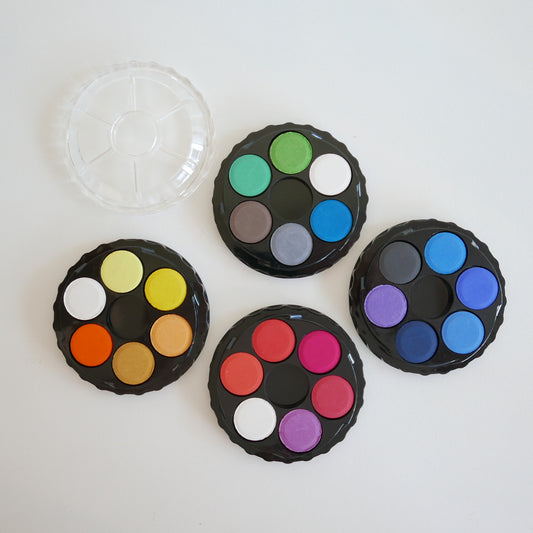 Four round color palettes with various colors on a white background
