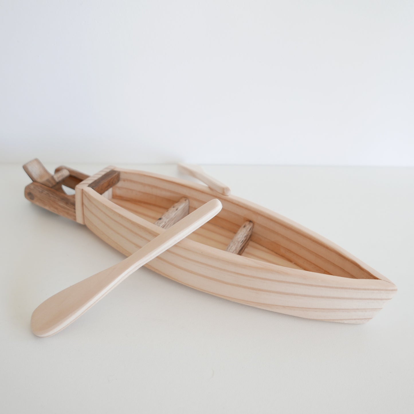 Wooden toy boat with a paddle for children