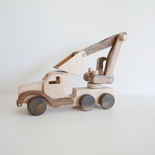 Wooden toy truck with crane on a light background